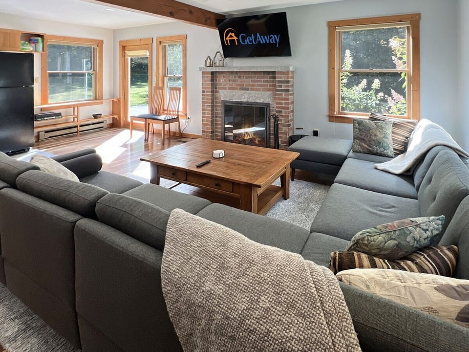Spacious living room with sectional seating, cozy fireplace, and a large TV.