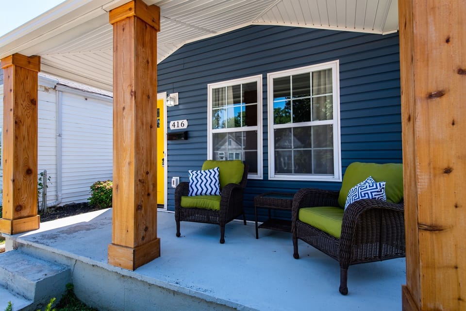 Sip your morning tea on the covered front terrace in one of the dark wicker chairs topped with bright green cushions. It is a fantastic little nook to watch the neighborhood wake up.