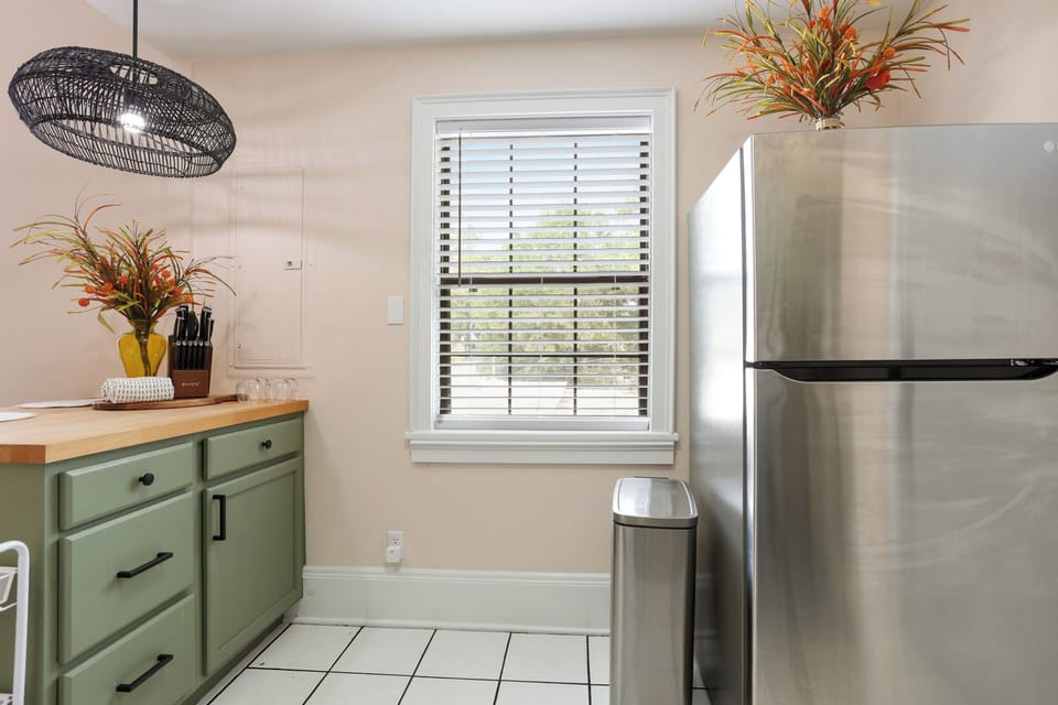 The kitchen is fully equipped with new appliances and a soft green finish.