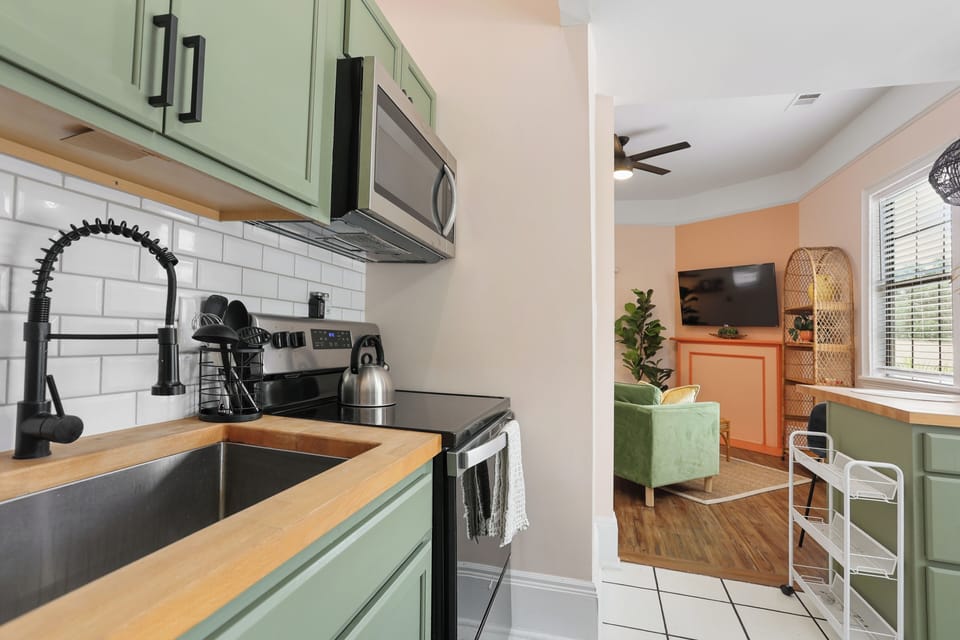 The kitchen is fully equipped with new appliances and a soft green finish.