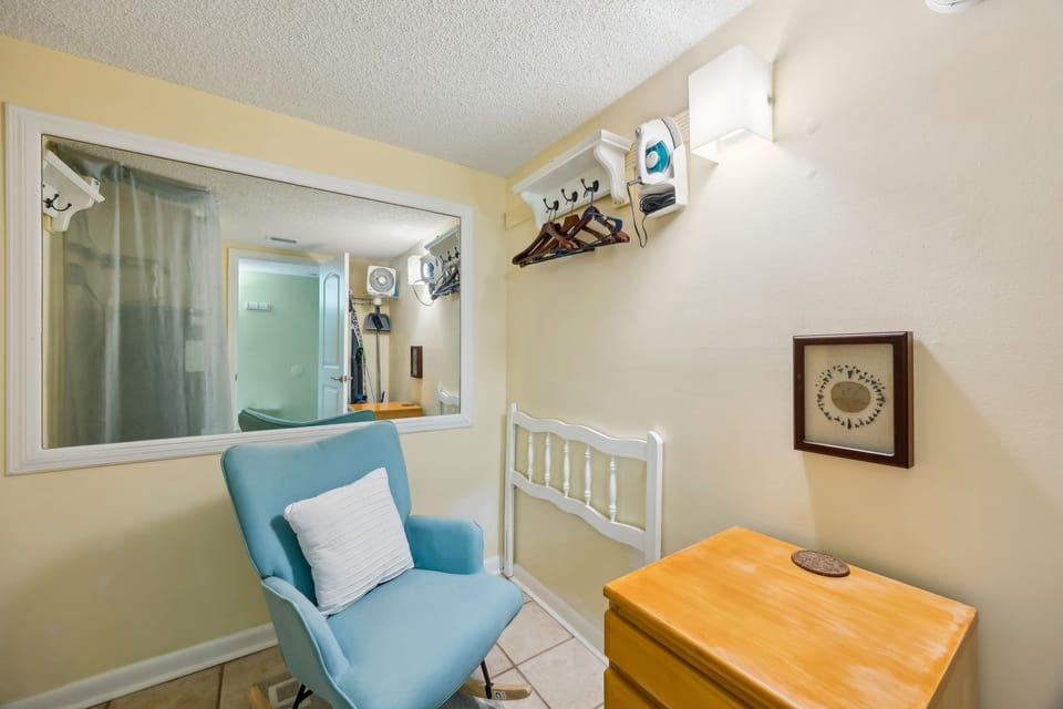 Small sitting room with glider and drawers (hot water heater located here)