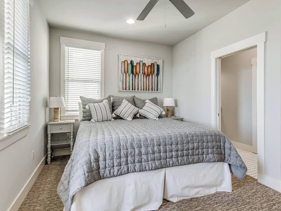 Bedroom #3 with king bed, private balcony with seating for 2, and attached jack and jill full bathroom