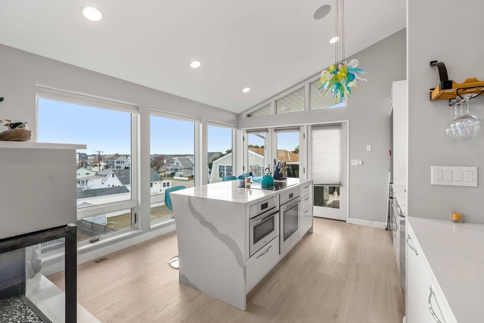 Completely renovated and fully equipped kitchen with high end Miele appliances, including an induction stove top and dishwasher. The picture windows in the space are sure to amaze!