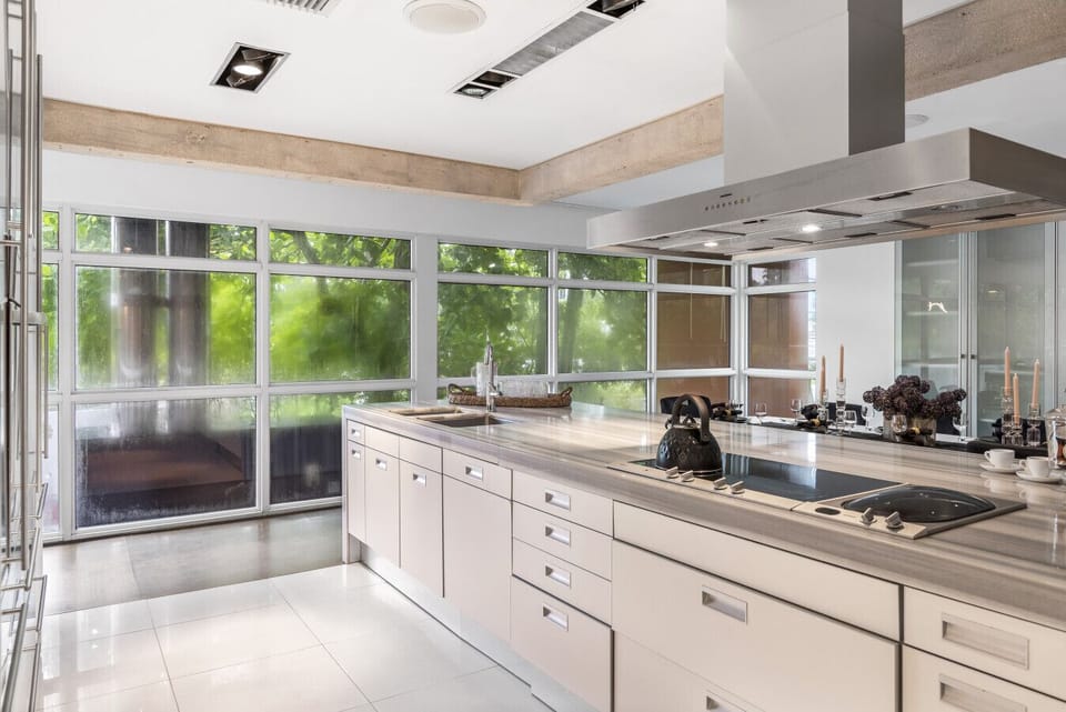 Beautiful Contemporary Kitchen featuring White Cabinetry Spacious Island and Professional Grade Appliance