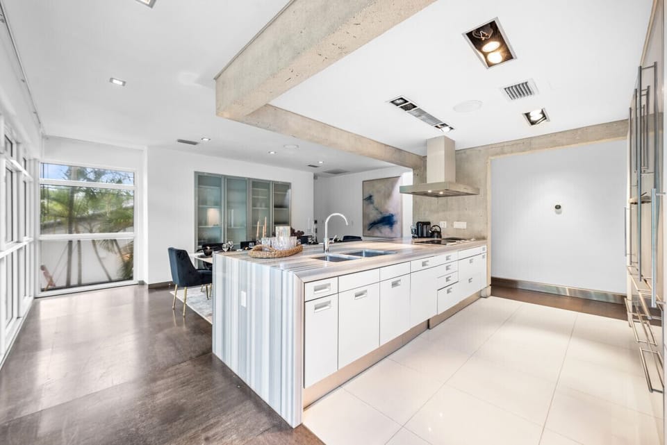 Elegant Open Floor Plan Kitchen featuring Modern White Design and Spacious Layout Perfect for Groups