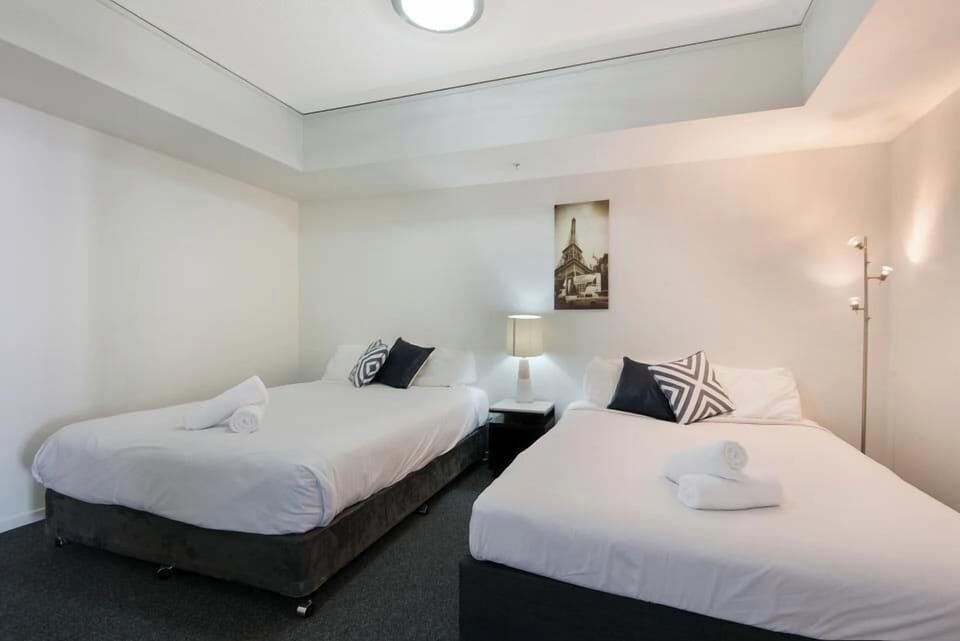 Twin beds arranged under soft lighting