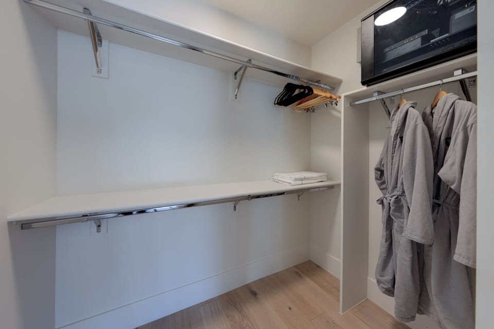 Walk in closet with plenty of storage and complimentary robes