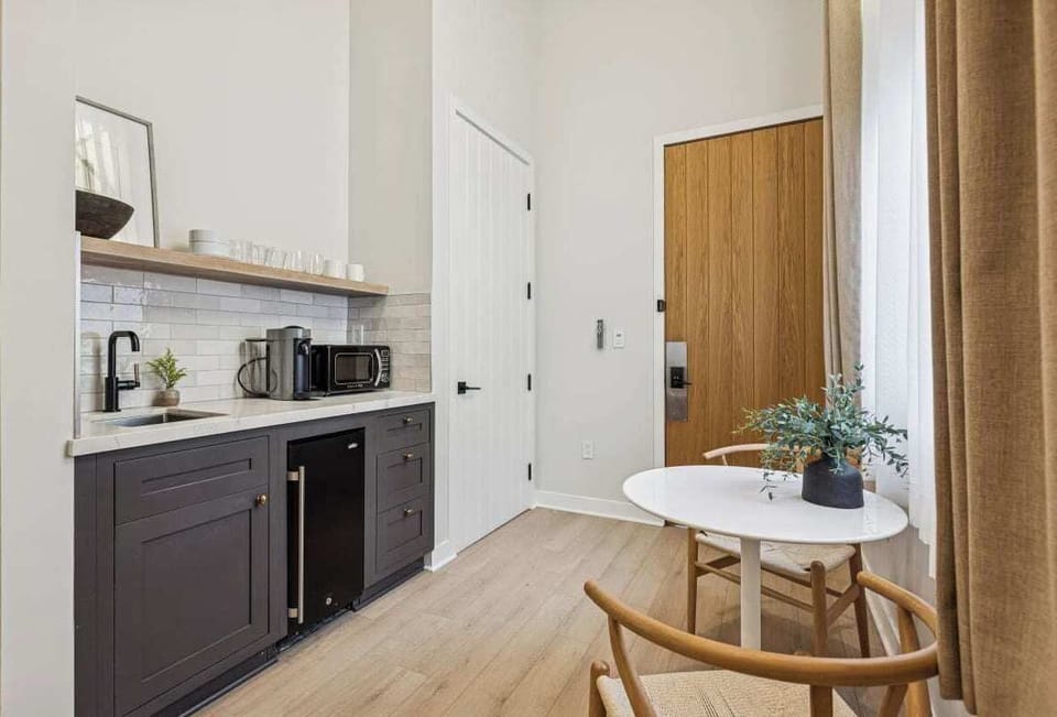 Kitchenette with mini-fridge, sink, and a Nespresso (no stove)
