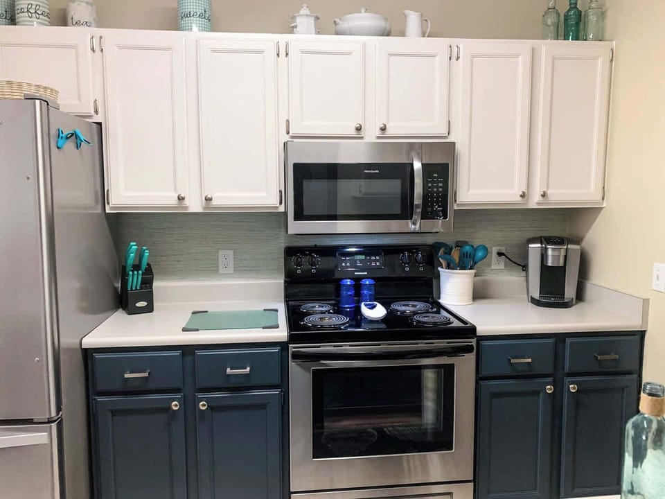 This Hilton Head condo kitchen features fun blue cabinets, stainless steel appliances, and a clean, coastal feel. A bright, open layout makes it easy to prep meals, enjoy casual breakfasts, and gather together after a day at the beach.