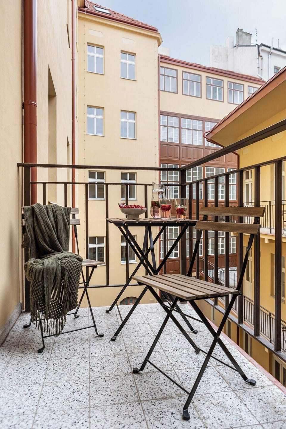 Traditional gallery-style balcony (pavlač), a shared space typical for historic Prague houses. Guests can enjoy a shared balcony in gallery style, offering outdoor seating right by the apartment.
