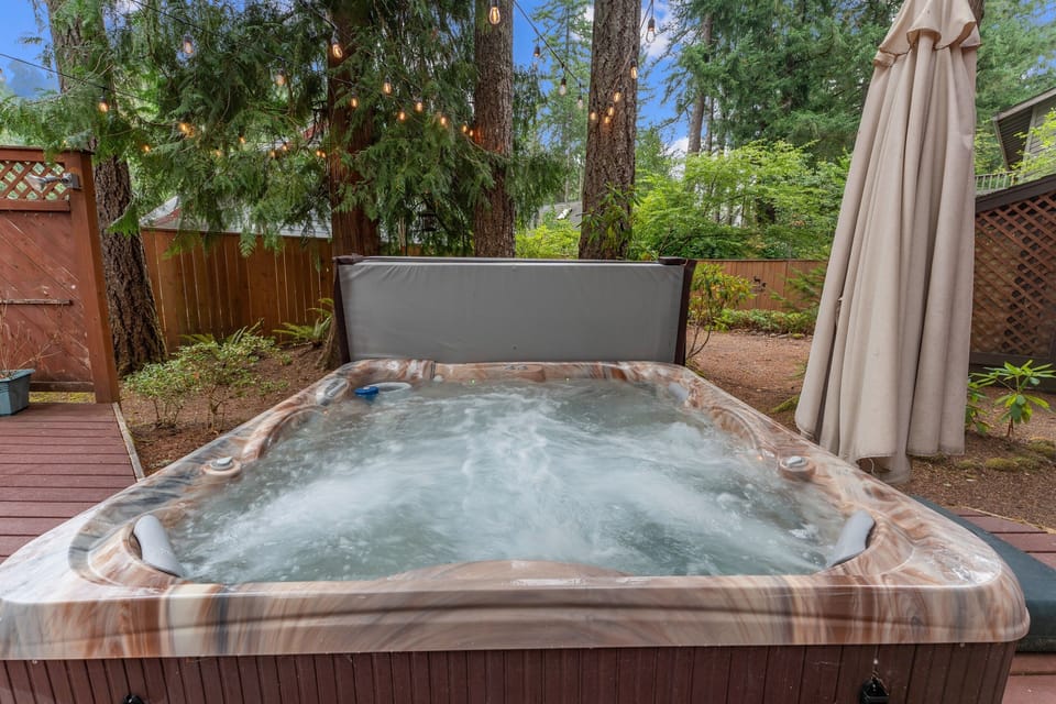 Hot Tub Oasis: Unwind in nature with a soothing soak under the stars and twinkling lights!