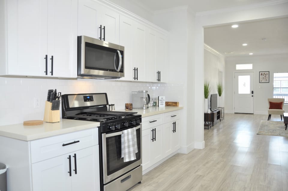 Modern all-white kitchen with stainless appliances and essentials for every stay