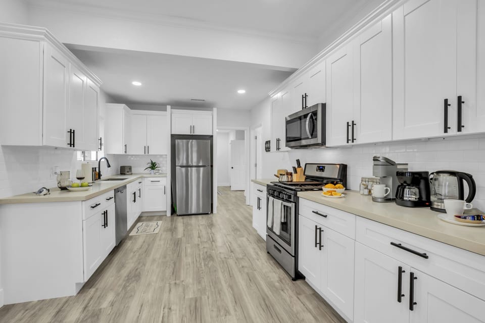 White shaker cabinets, black hardware, stainless appliances, subway tile.