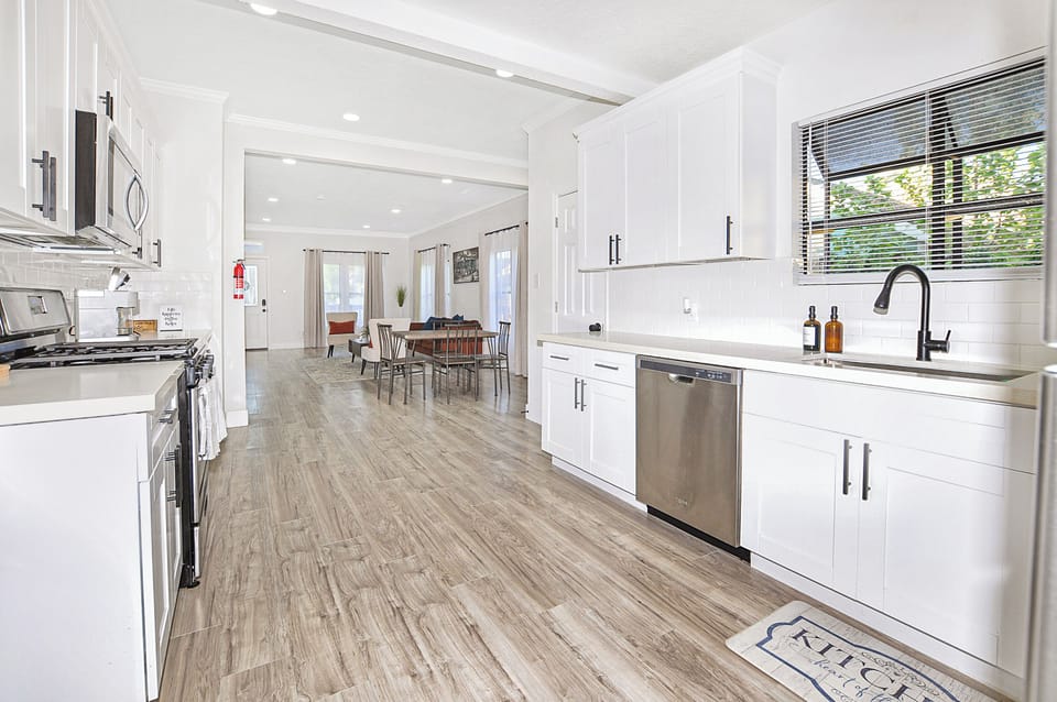 Sleek white cabinetry and stainless steel appliances make cooking a delight.
