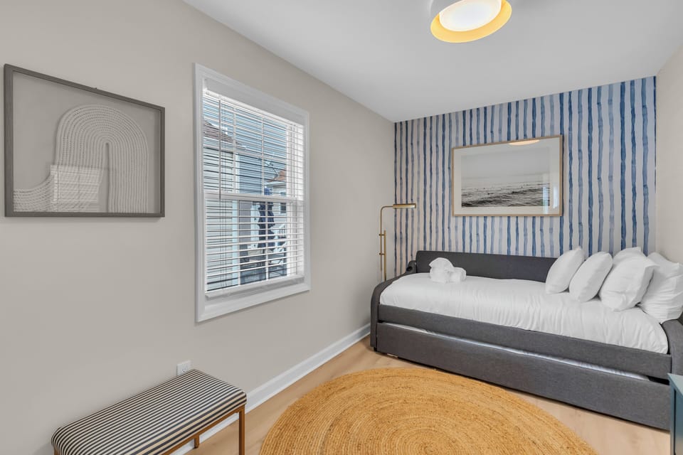 Bright guest room with daybed + trundle, coastal accents and window light