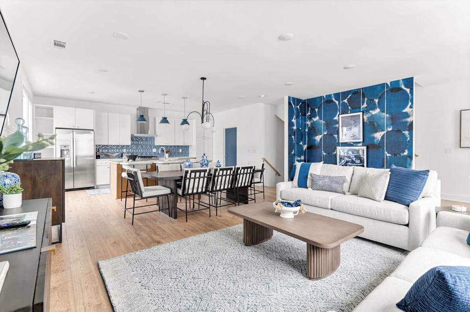 The living room opens straight into the kitchen and dining area. No walls between you and whoever's cooking, no reason for anyone to feel left out of the group