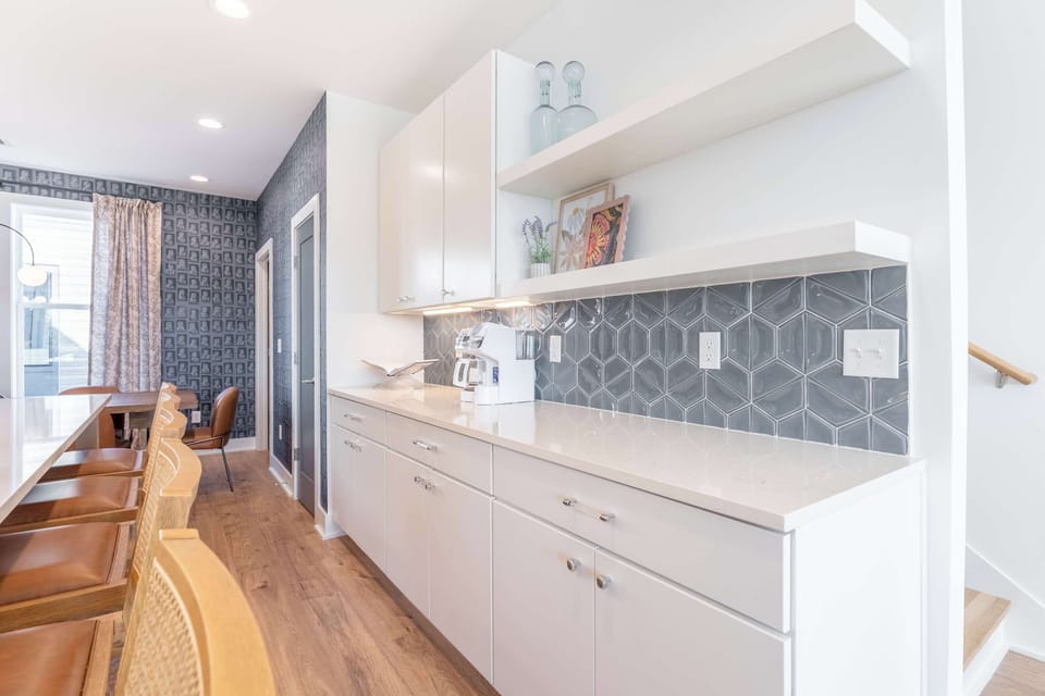 Coffee and breakfast prep happen here, where the countertops meet a tile backsplash that actually looks good while you're making the morning run
