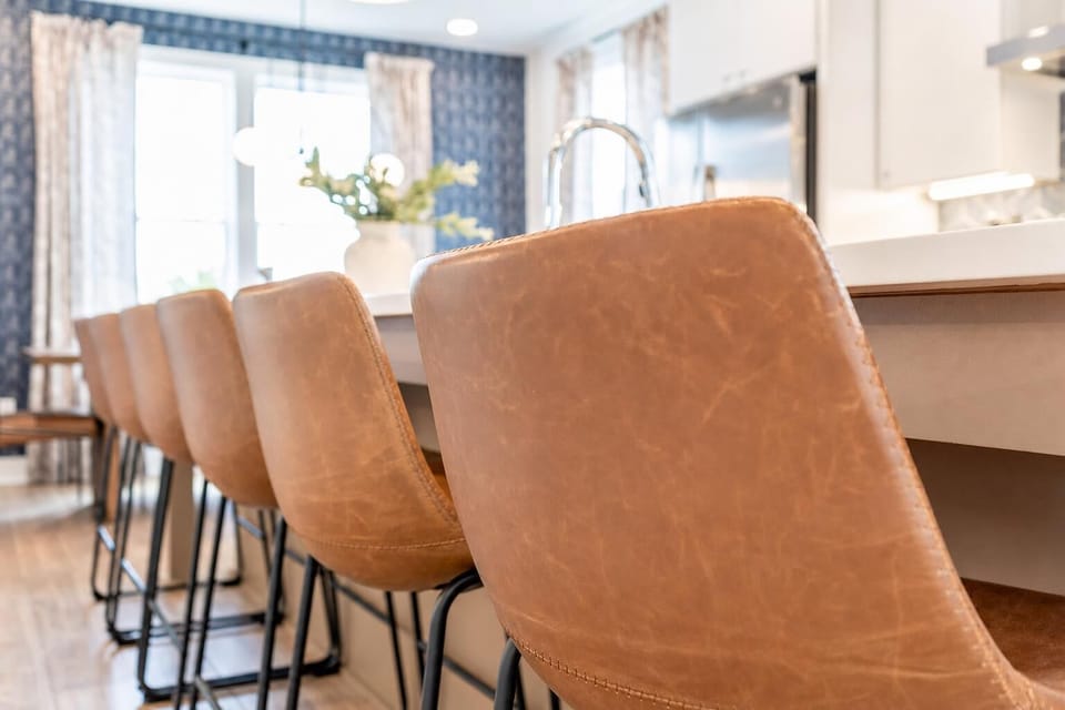 Gather around the leather bar stools at the kitchen island where a group of 12 can cook, eat, and never miss a beat of the conversation