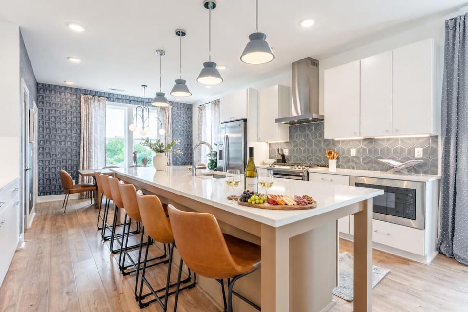 A gas range, dishwasher, and island seating mean meal prep for a crowd stays manageable, and the hardwood floors keep the whole space feeling open and connected