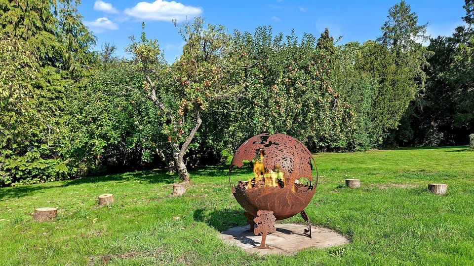 Stroll through the bountiful apple trees to the fire sphere surrounded by its log seating.