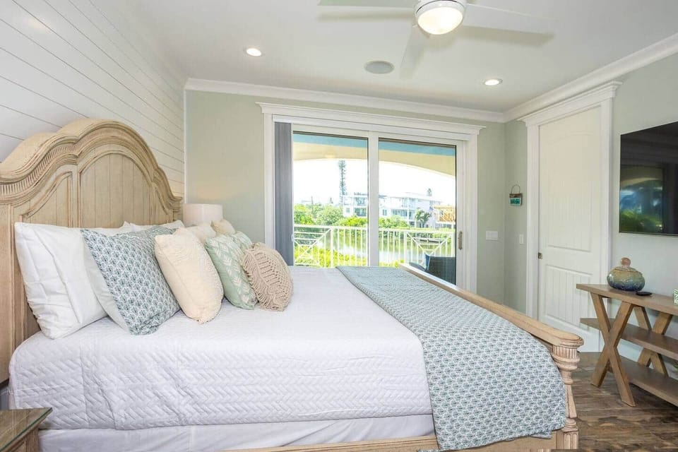 Primary suite king bed, private balcony overlooking pool and canal