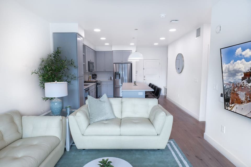 Beautifully designed living room. 65` TV, leather sofa and amazing views of mountains and city skyline.