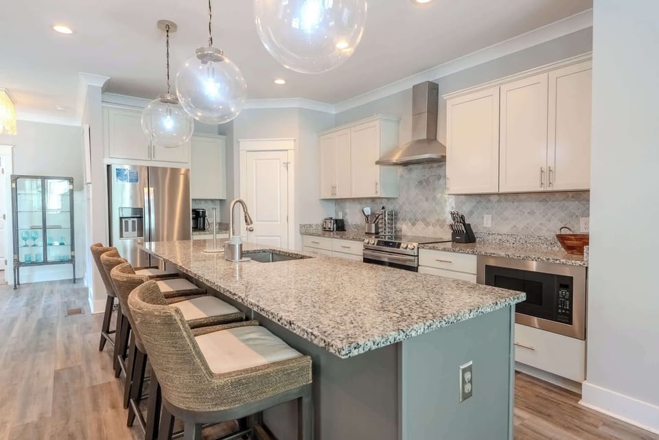 Open-concept kitchen with modern appliances, a central island, and casual bar seating.