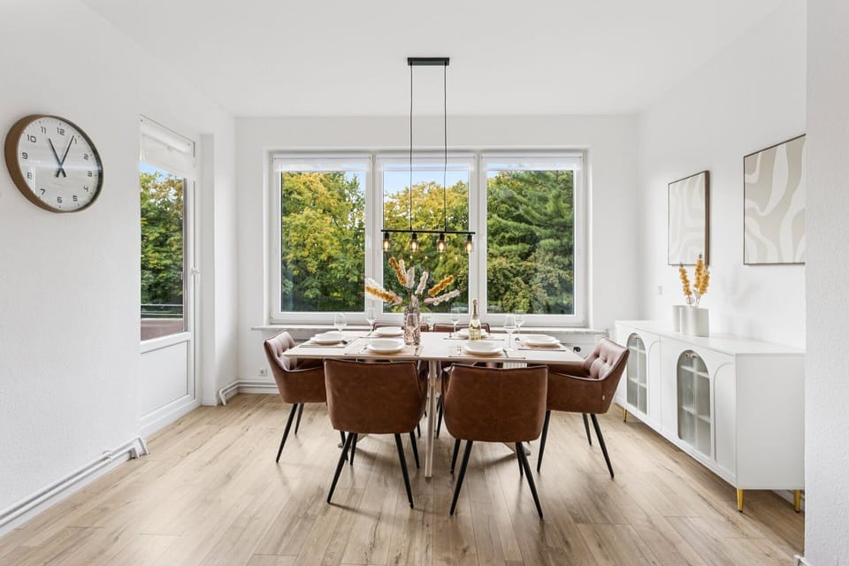Ein großzügiger, lichtdurchfluteter Essbereich mit stilvoller Einrichtung und Ausblick ins Grüne bietet den perfekten Ort für gemeinsame Mahlzeiten.