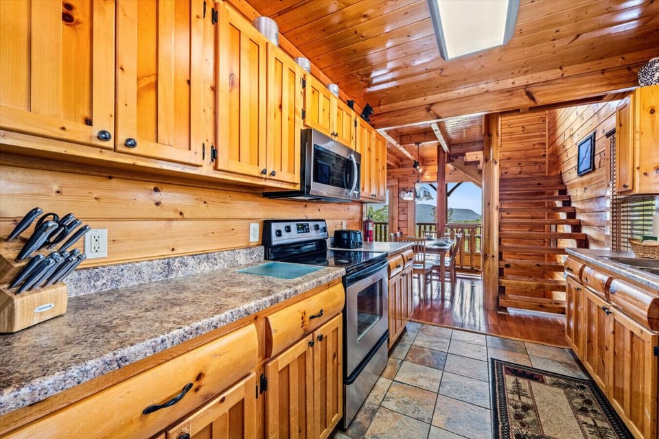 This charming log cabin kitchen is fully equipped for meals with a view. Cook, dine, and gather around the table—all while gazing out at the mountains.
