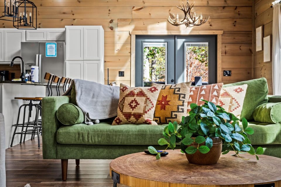 Earthy tones, handcrafted pillows, and that rich green couch set the vibe for laid-back mornings and quiet evenings.