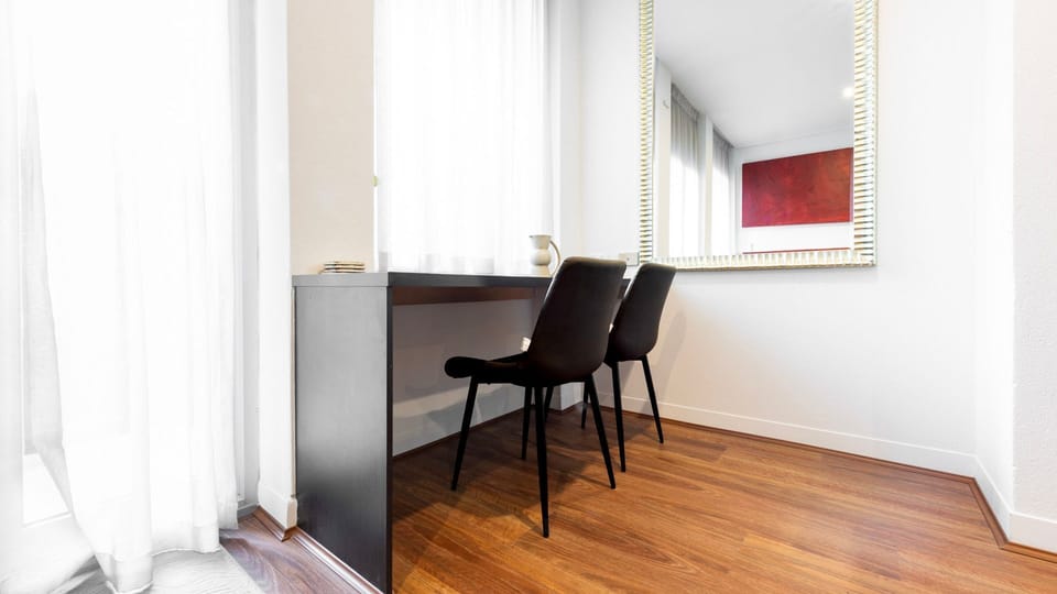 Dining corner with chairs, desk-style table, and large mirror