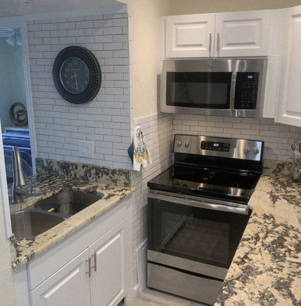 indoor, kitchen, oven, stovetop, microwave, refrigerator opposite 