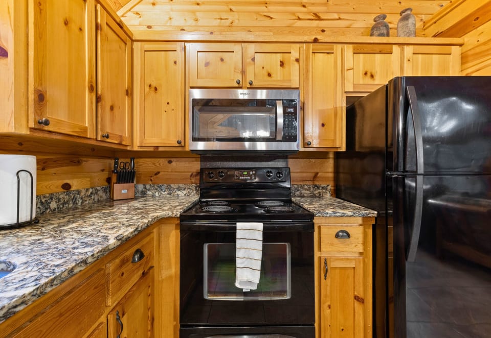 Fully equipped kitchen with granite counters and woodsy charm