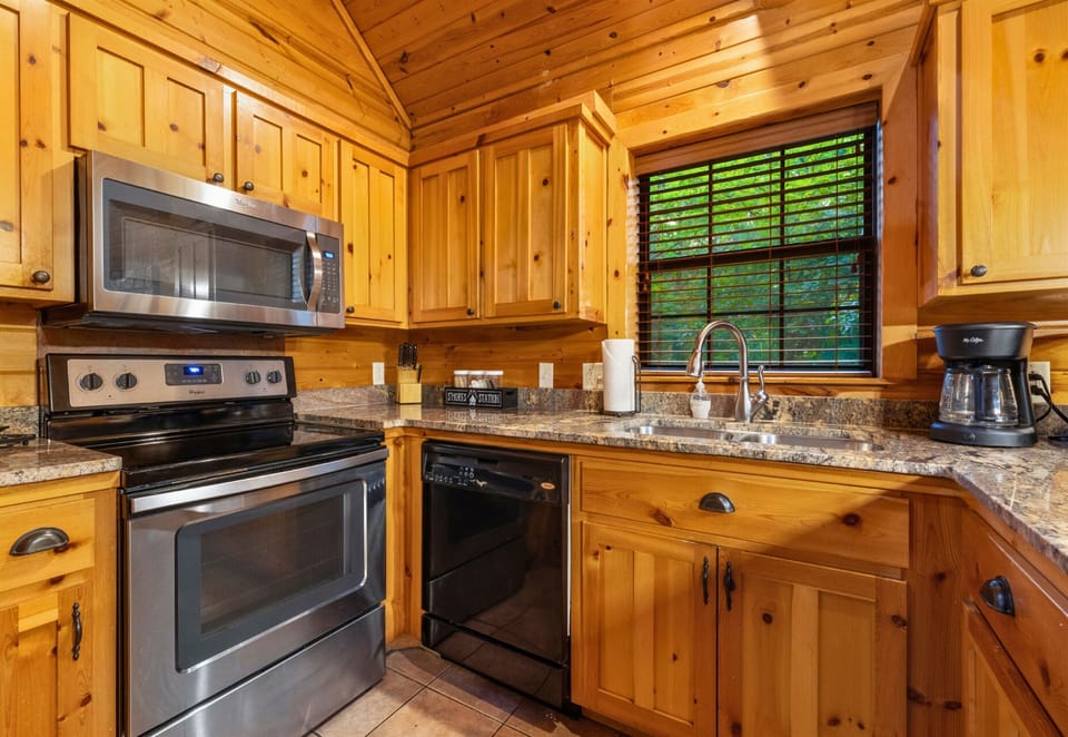 Stainless appliances and cabin-style cabinetry in the kitchen.