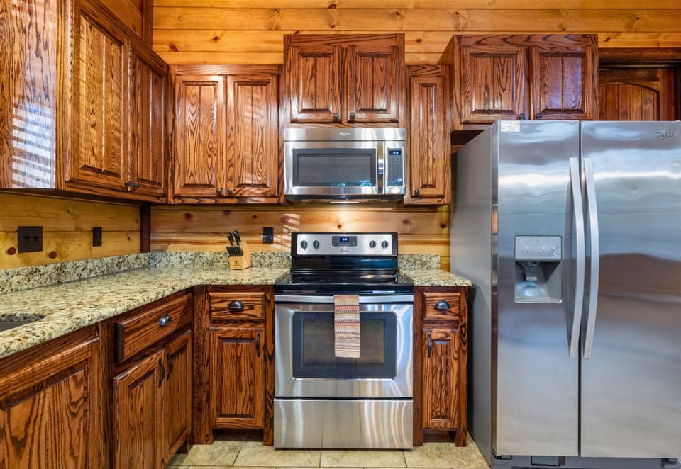Fully equipped kitchen with stainless steel appliances and granite countertops.
