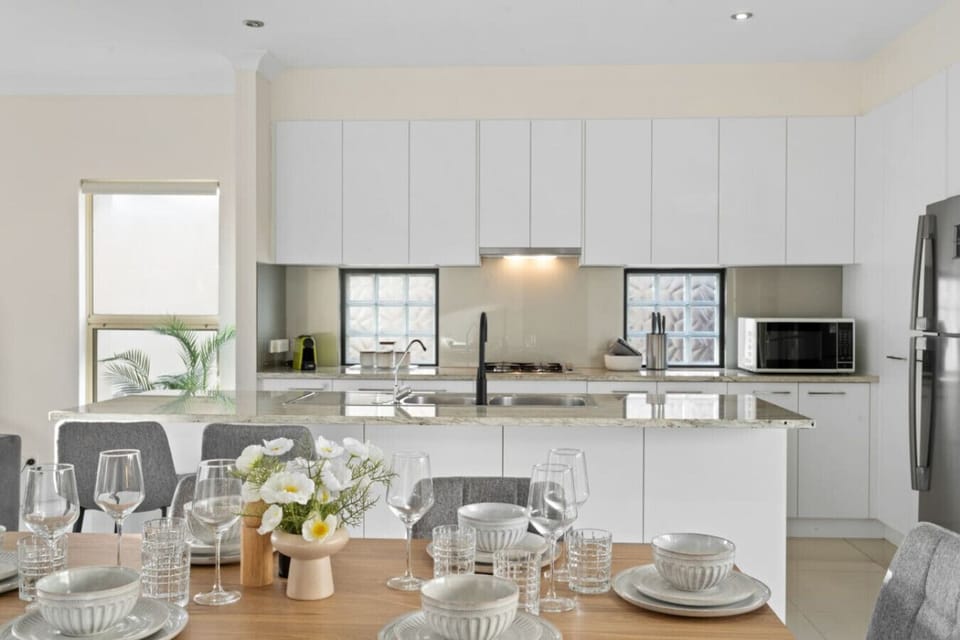 Start your day at the breakfast bar, where sleek stone surfaces and comfortable stools create the perfect spot for morning coffee or casual bites.