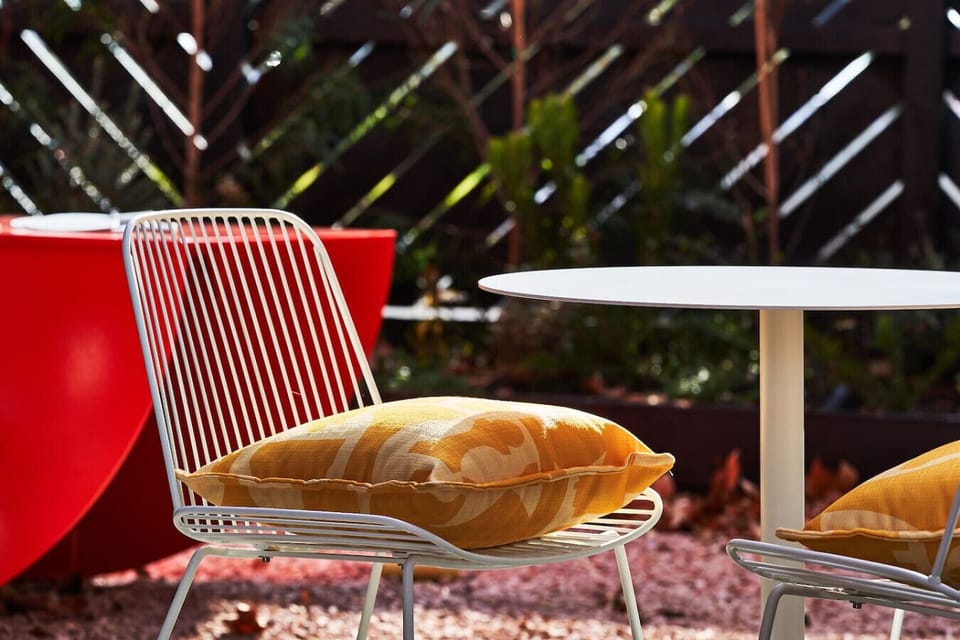Soak up the afternoon sun while relaxing with a fresh beverage at this comfortable backyard bistro table.