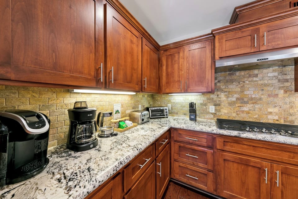 Your gourmet kitchen awaits with granite countertops, warm cherry cabinets, and stone backsplash creating the perfect space for memorable meals.