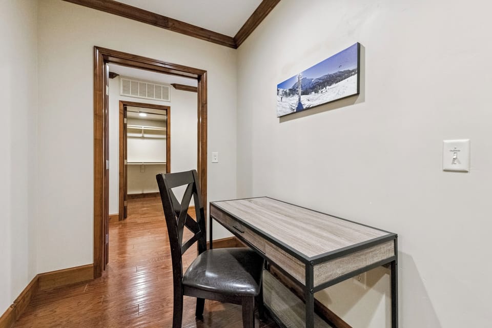 Your private workspace awaits with polished hardwood floors, rich wood trim, and inspiring mountain artwork.