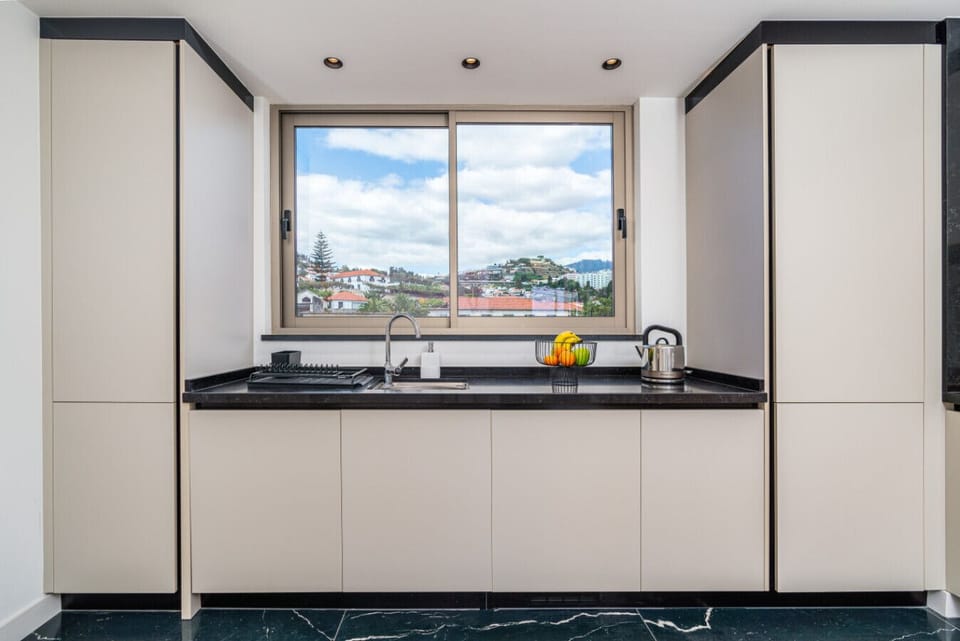 Bright kitchen with panoramic window and peaceful city views.