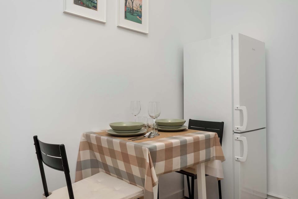 Another view of the kitchen and dining space with a round table and chairs. The room feels airy and bright.