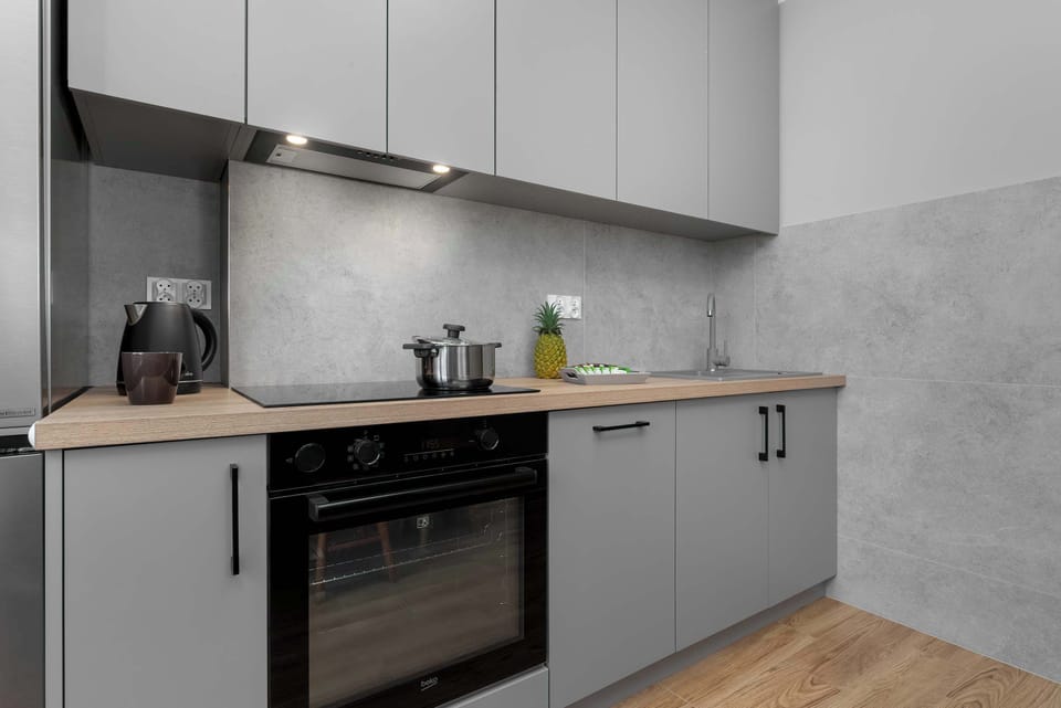 Another angle of a sleek kitchen with gray cabinets and built-in appliances. The layout is functional and compact.
