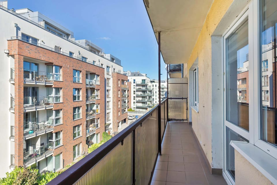 Another balcony perspective showing the urban environment. The railing and floor are simple and clean.