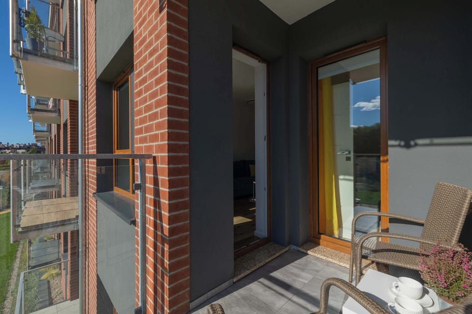 Spacious balcony with outdoor furniture. 