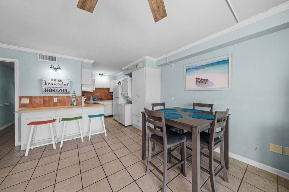 Colorful bar stools, a fully equipped kitchen, and a dining table for four — everything you need to cook, eat, and enjoy your PCB home away from home!