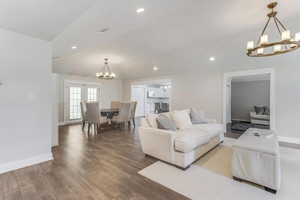 Expansive open-concept layout with plush seating and adjacent dining area, great for group gatherings.