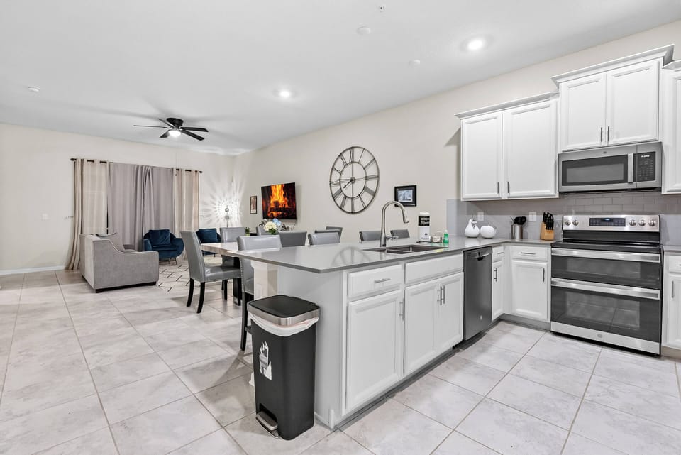 Experience a bright kitchen featuring sleek white cabinets and modern stainless-steel appliances. The spacious island is perfect for meal prep, seamlessly connecting to a cozy dining area for enjoyable shared meals.