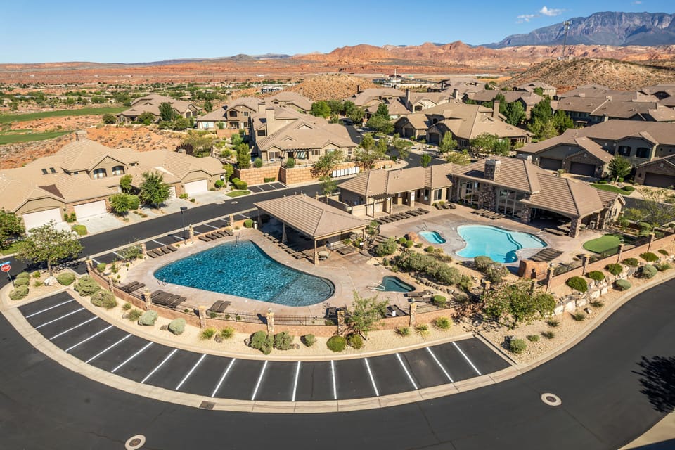 Expansive resort pool and hot tub surrounded by lounge seating, perfect for relaxation.