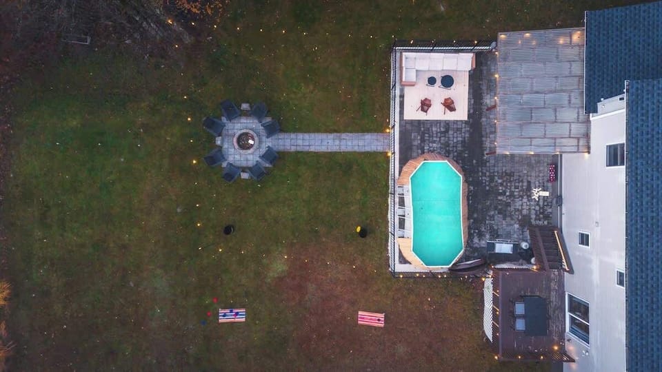Overhead view of the backyard w/ pool, lawn games, & outdoor areas