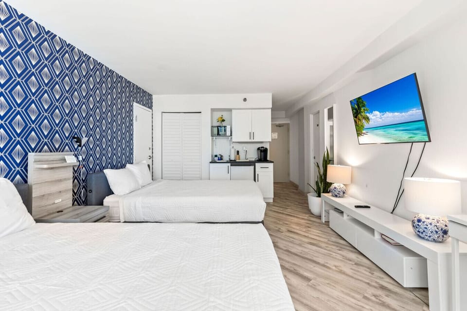 View of studio with two queen beds and smart TV